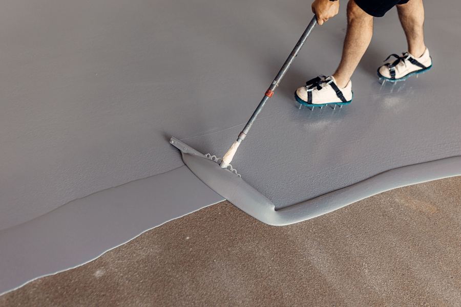 Rolling out the basecoat on a garage floor
